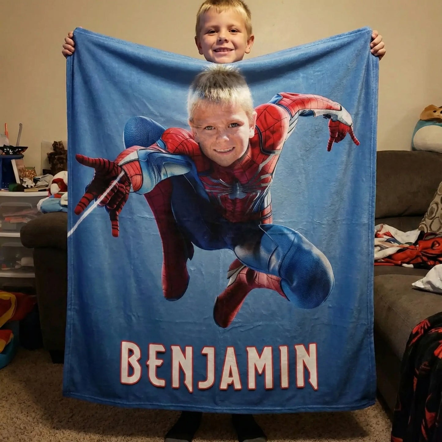 Boy holding a spiderman blanket in his room