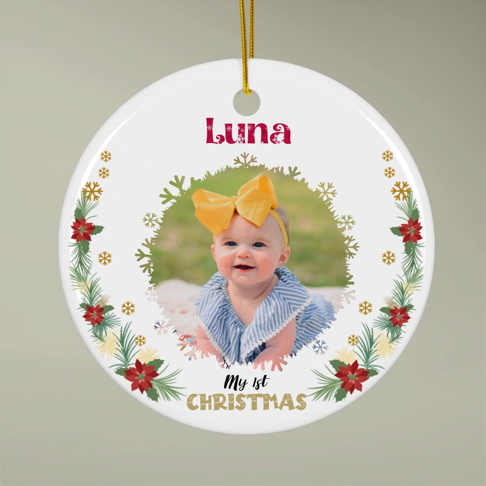 Round baby first Christmas ornament with a photo and name on a plain background