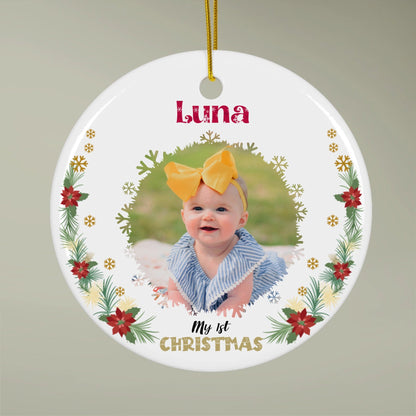 Round baby first Christmas ornament with a photo and name on a plain background