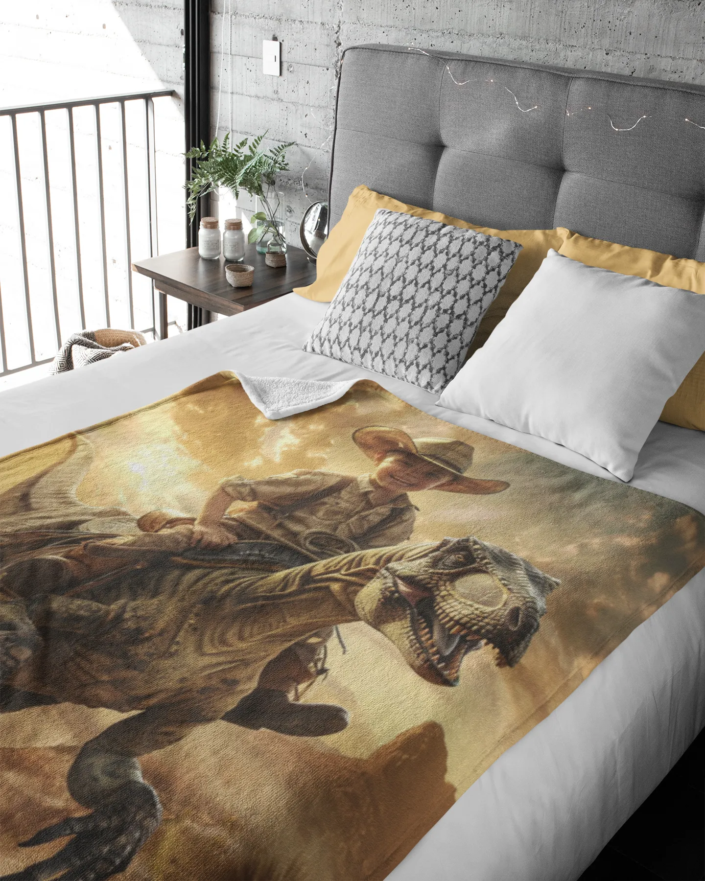 Bed with dinosaur and cowboy design blanket in a room with a gray headboard and window.

