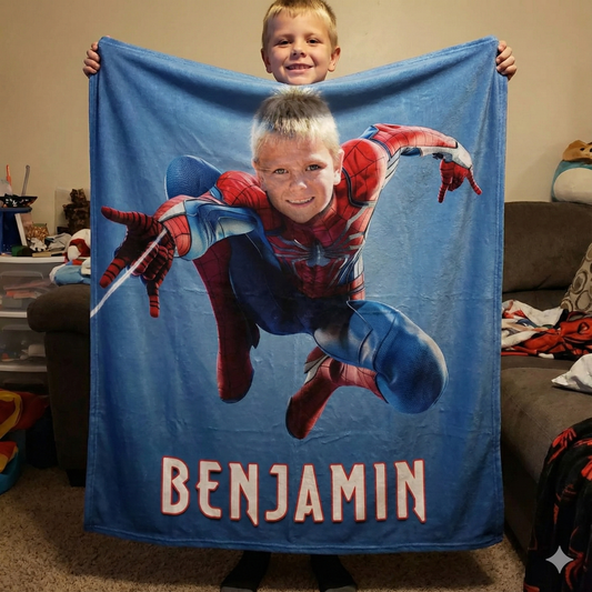 young boy holding spiderman blanket in his room